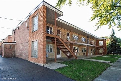 a large brick apartment building with a staircase