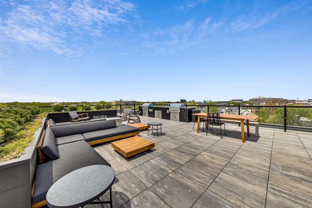 a rooftop deck with couches and tables