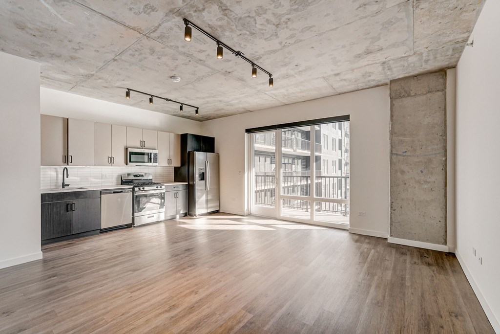 A kitchen with wooden floors and a large window.