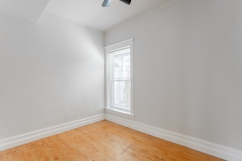 A room with a window and wooden floor.