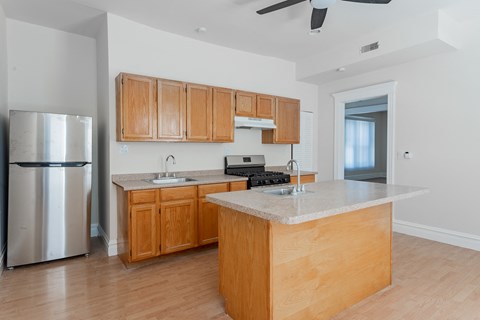 A kitchen with wooden cabinets and a marble countertop.