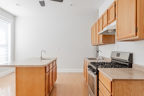 A kitchen with wooden cabinets and a stove top oven.