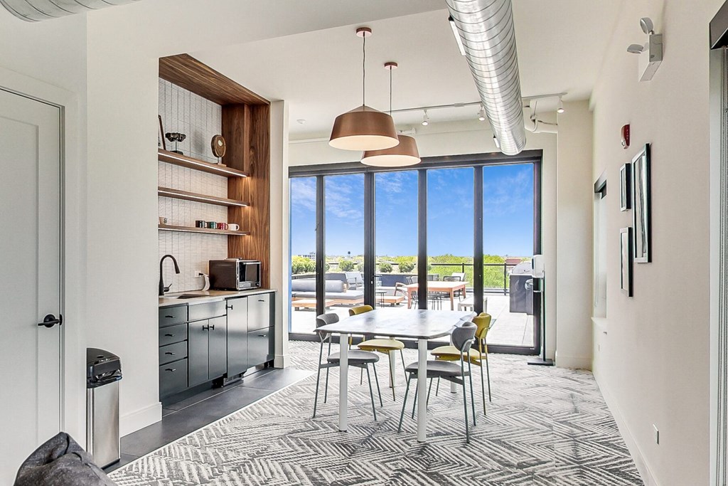 a dining area with a white table and chairs and a large window with a view of a