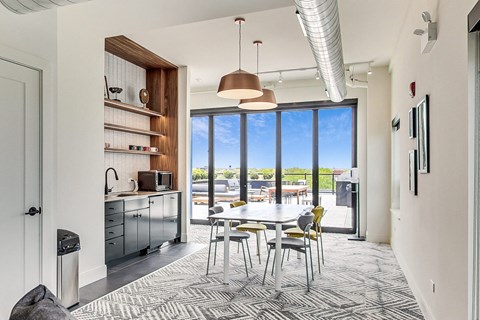a dining area with a white table and chairs and a large window with a view of a