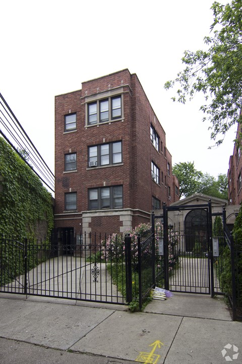 a tall brick building with a gate in front of it