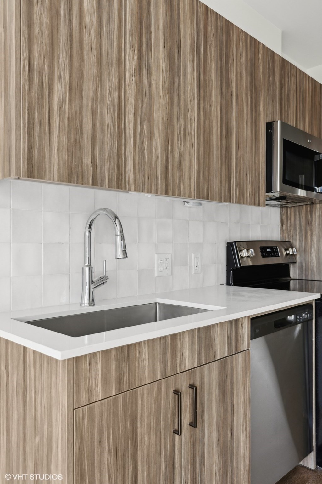 A modern kitchen with wooden cabinets and a stainless steel dishwasher.