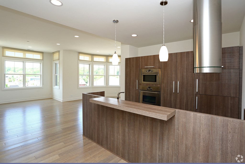 A modern kitchen with wooden cabinets and a stainless steel range hood.