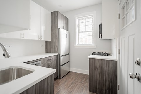 a kitchen with white cabinets and a stainless steel refrigerator