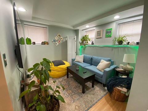 A living room with a yellow bean bag chair and a blue couch.