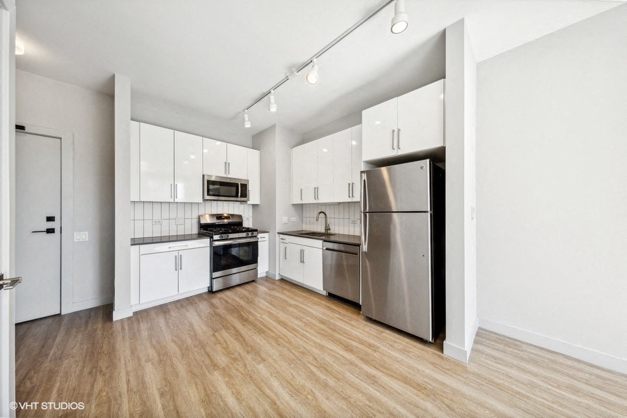 a kitchen with white cabinets and stainless steel appliances