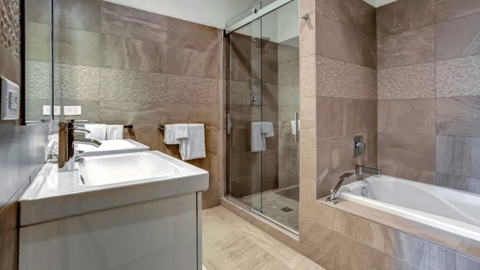 A modern bathroom with a sink, mirror, and bathtub.