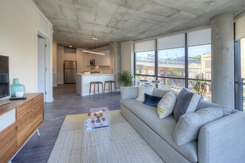 A modern living room with a grey sofa and a wooden cabinet.