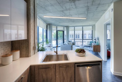 A modern kitchen with a stainless steel dishwasher and wooden cabinets.