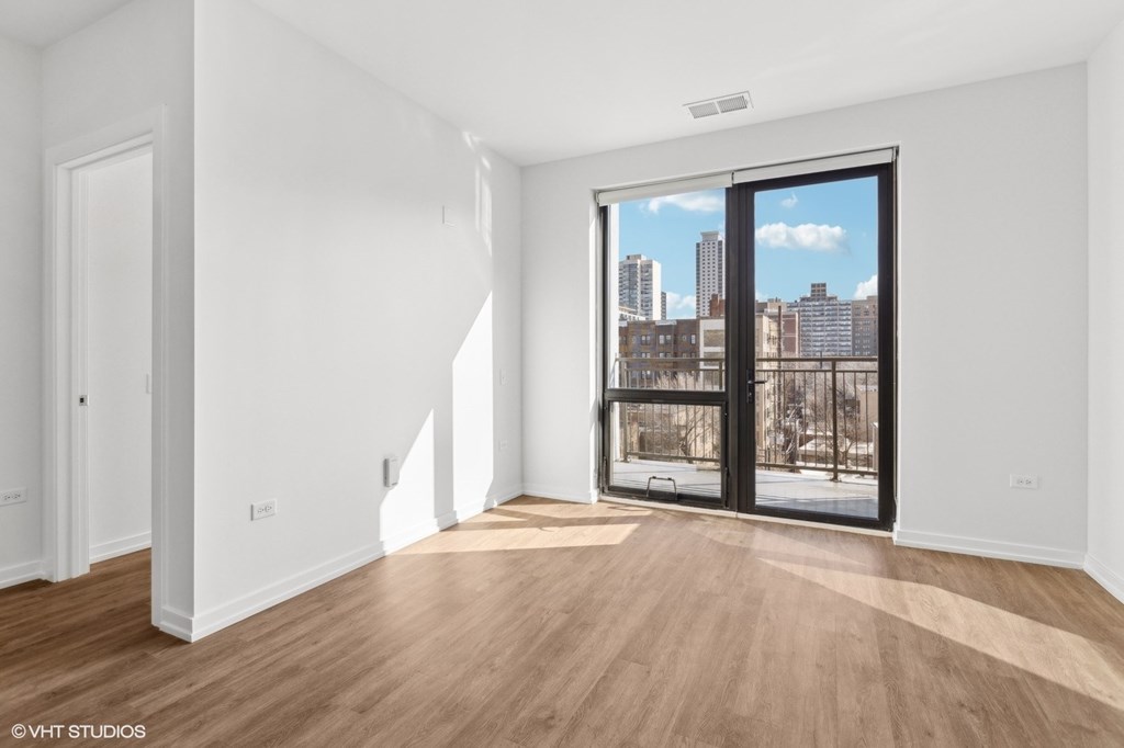 A room with a view of the city through a large window.
