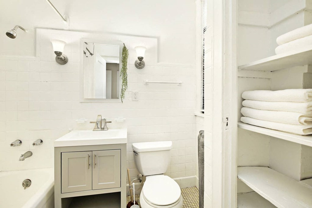 a white bathroom with a toilet and a sink