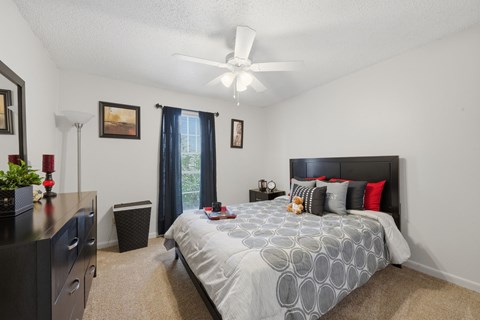 A bedroom with a large bed and a ceiling fan.