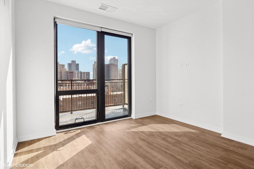 A room with a view of the city through a large window.