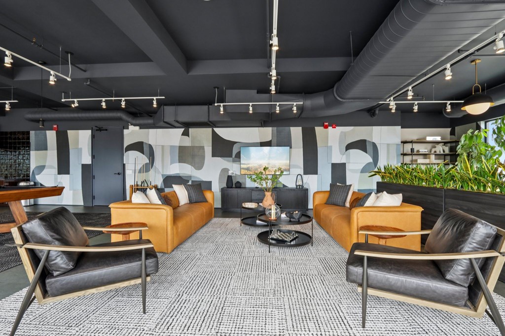A modern living room with black and orange furniture.