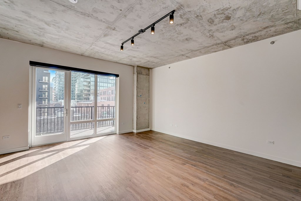 A room with a sliding glass door leading to a balcony.