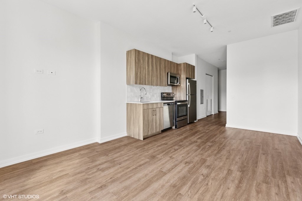A kitchen area with wooden floors and white walls.