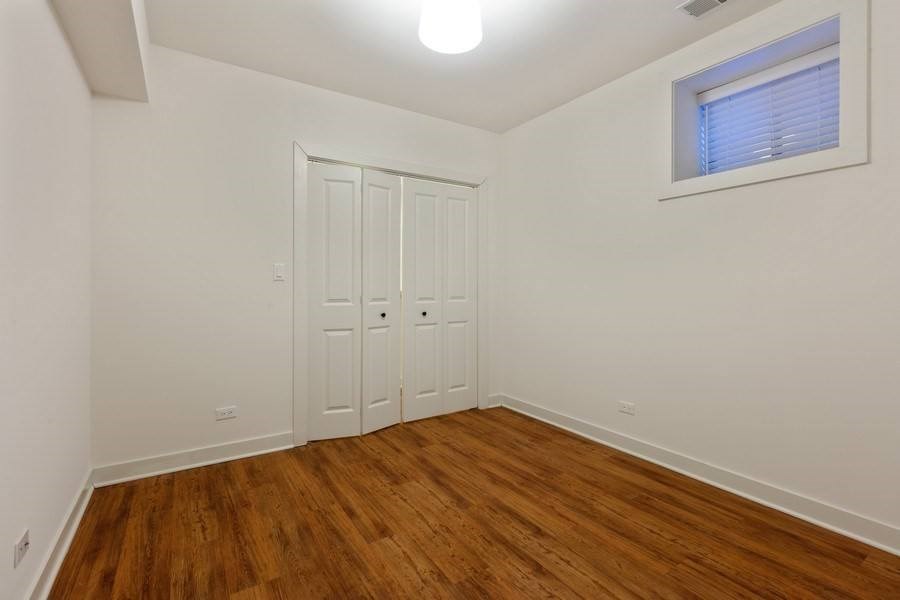 A room with a white door and wooden flooring.