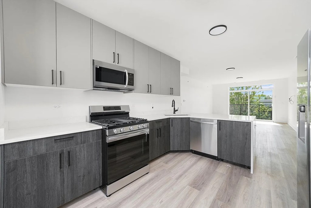 A modern kitchen with a stove top oven and microwave.