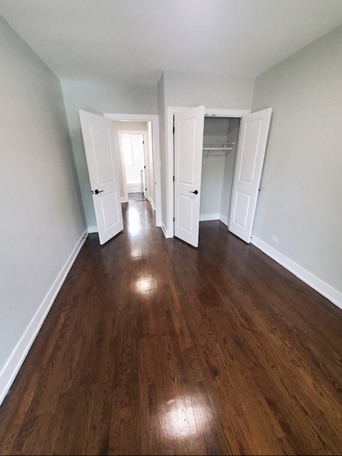 an empty living room with wood floors and white walls
