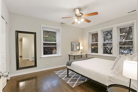 a bedroom with a large bed and a ceiling fan
