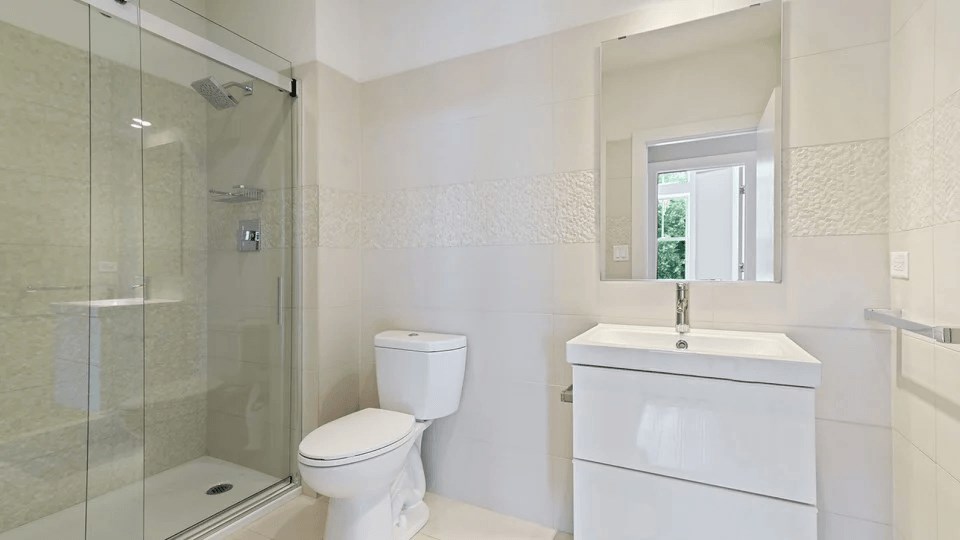 A white toilet and sink in a bathroom.