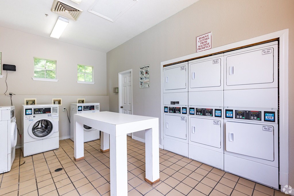 A laundromat with a row of washers and dryers.