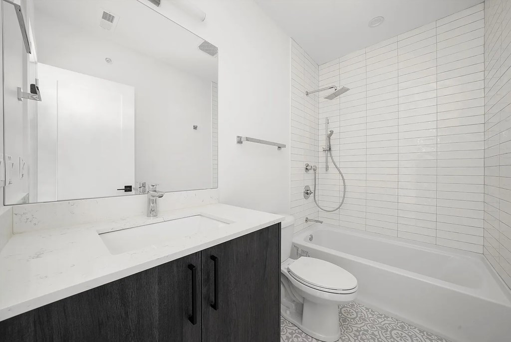 A white bathroom with a sink, toilet, and bathtub.