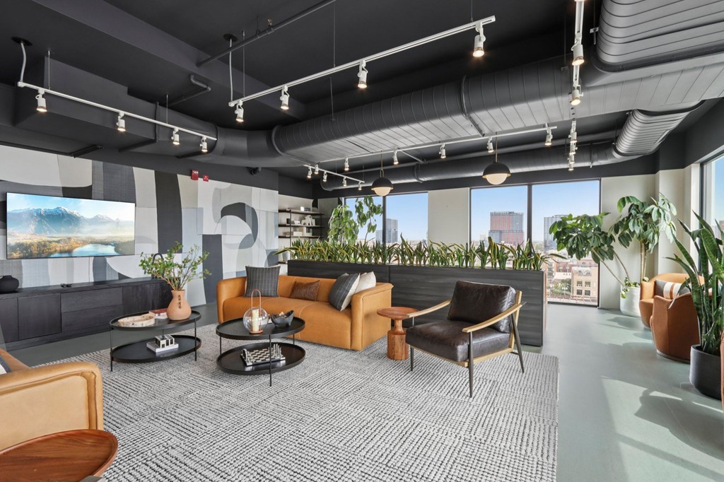 A modern living room with a grey carpet and a large window.