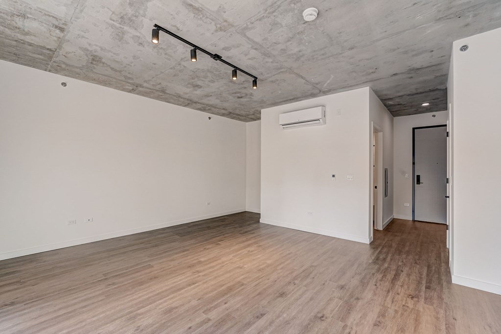 A room with a wooden floor and a white wall.