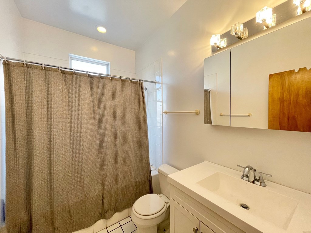a bathroom with a shower and a sink and a toilet