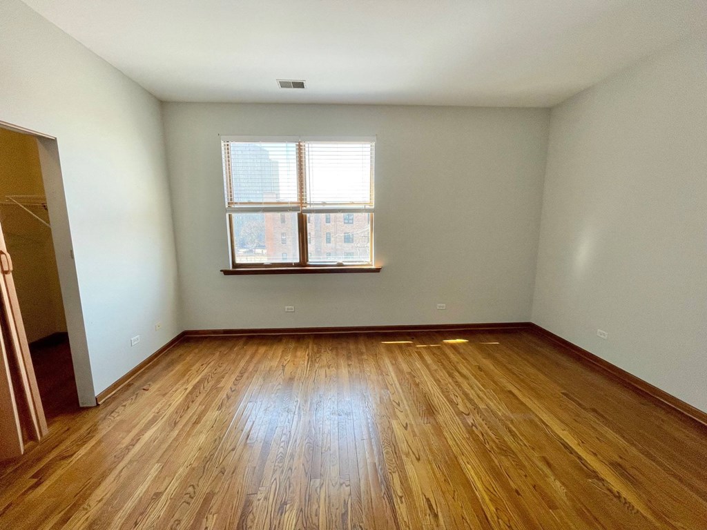 an empty room with wooden floors and a window