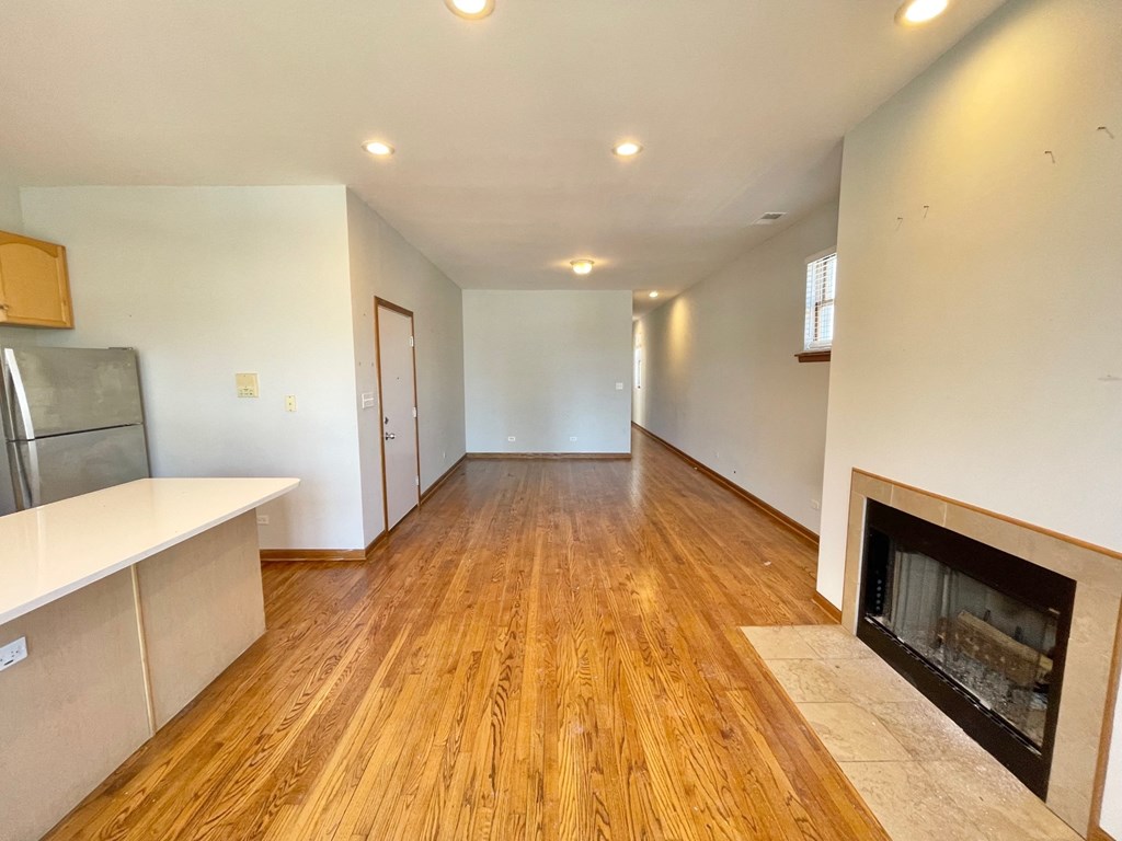 a living room with a fireplace and a hard wood floor
