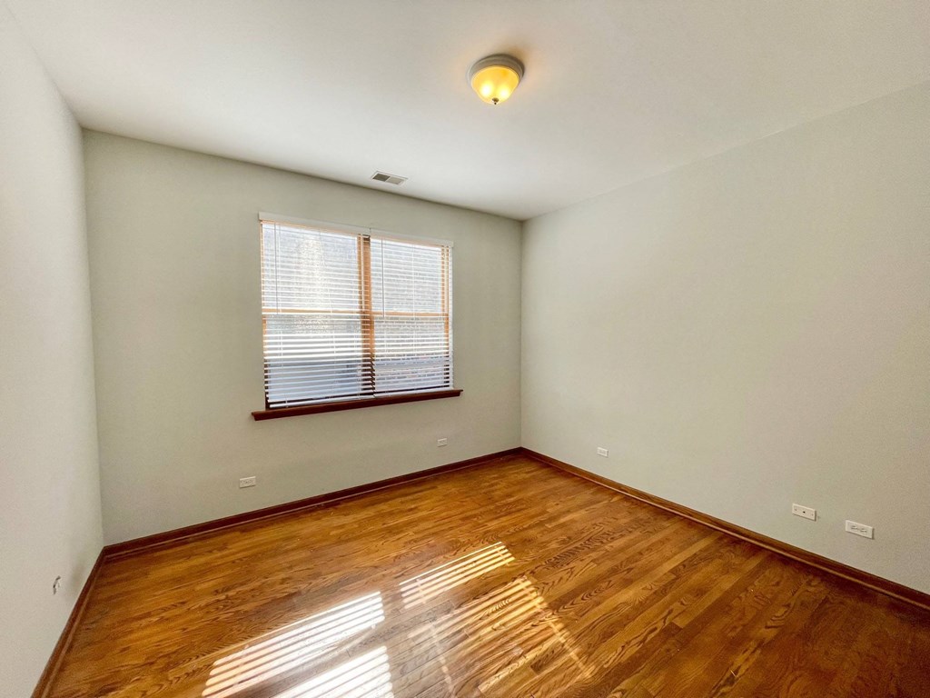 an empty living room with hardwood floors and a window