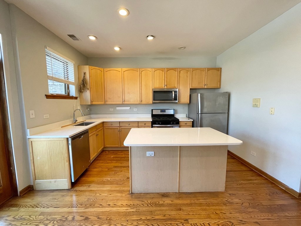 an empty kitchen with wooden cabinets and a white counter top