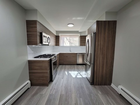 A modern kitchen with a stove top oven and a refrigerator.