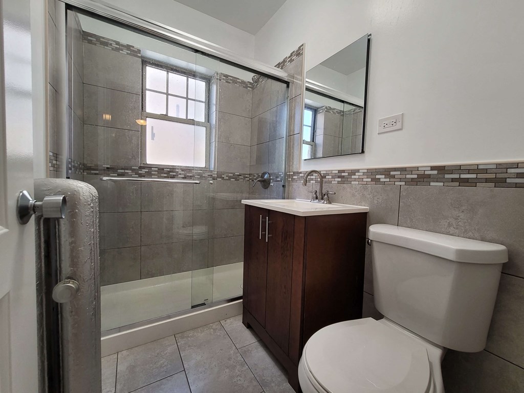a bathroom with a toilet and a sink and a shower