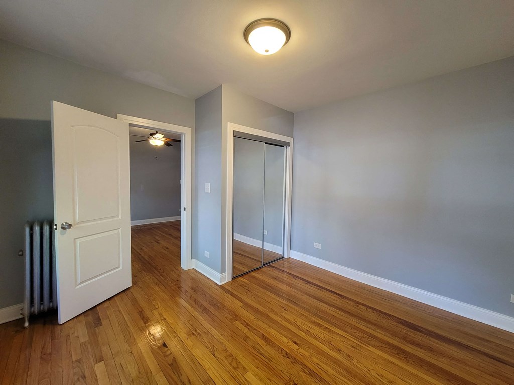 an empty living room with wood flooring and a door to a closet