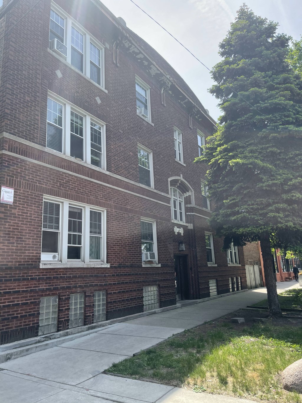 a brick building with a sidewalk in front of it