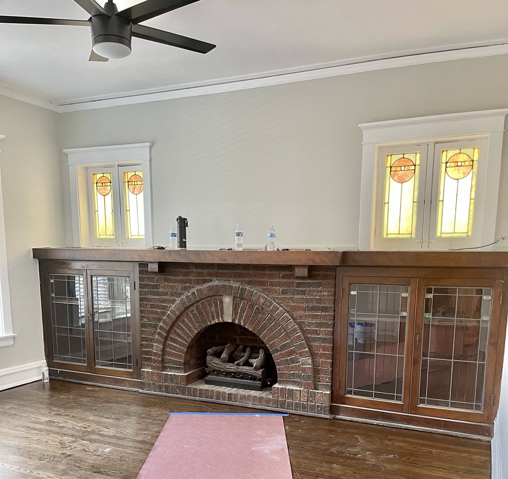 the living room has a brick fireplace and a large window