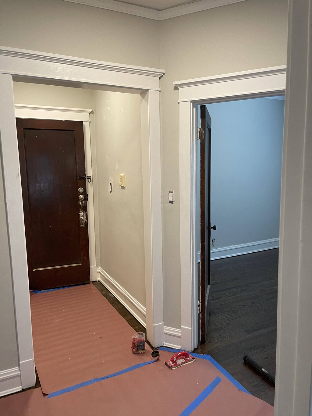 a living room with the door open and the hallway door open to the dining room