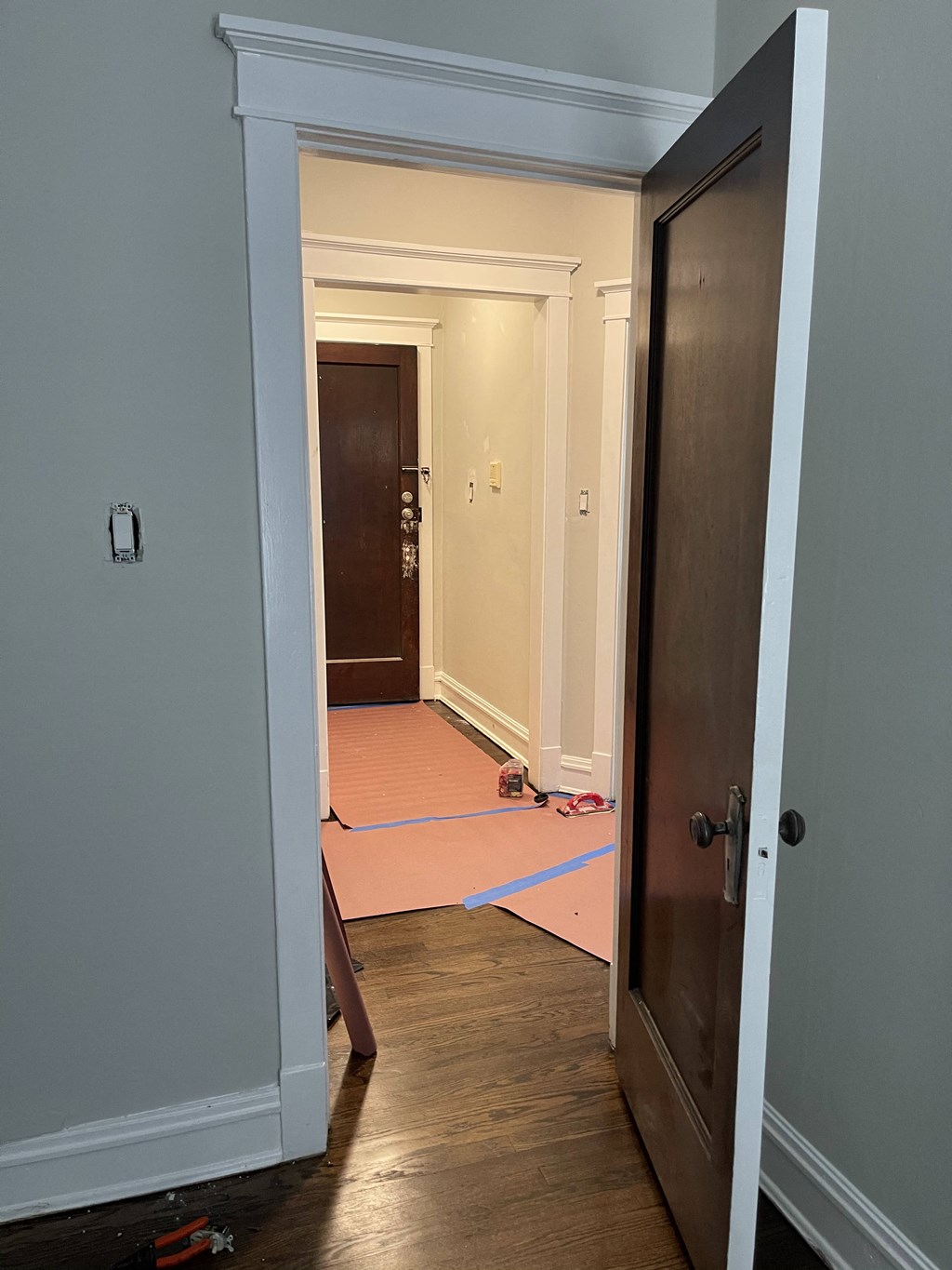 the door is open to the living room and the hallway is being remodeled