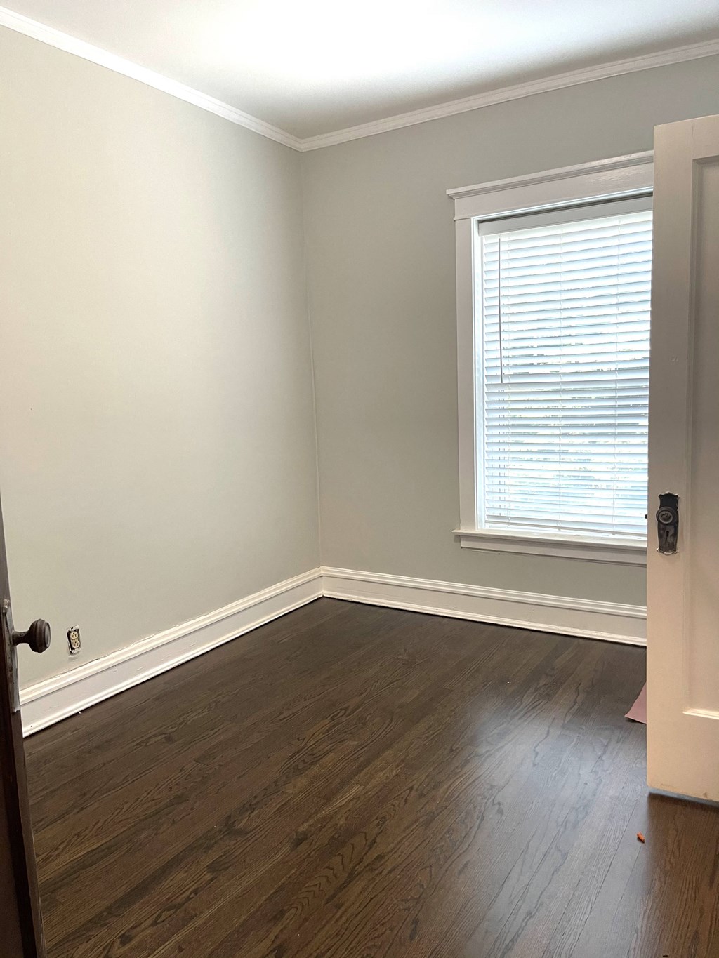 an empty room with wooden floors and a window