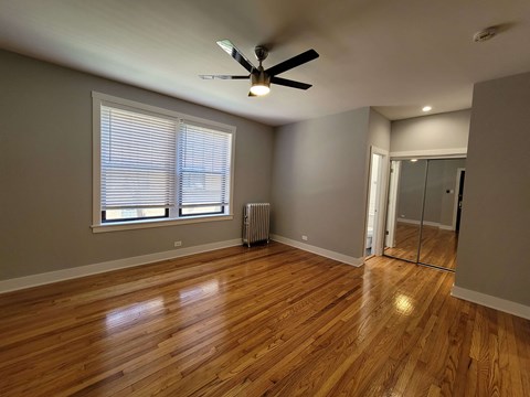 a living room with wood floors and a ceiling fan