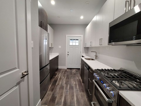 a kitchen with white cabinets and stainless steel appliances