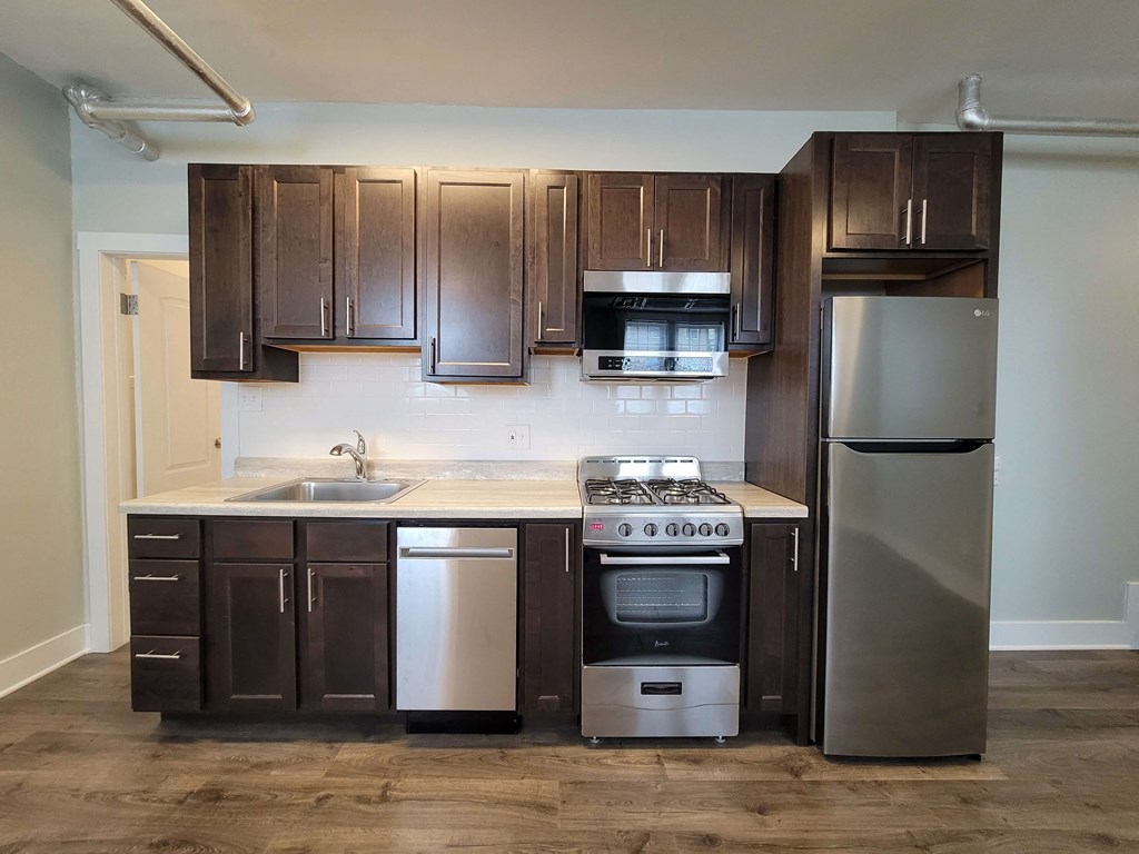 a kitchen with wooden cabinets and stainless steel appliances