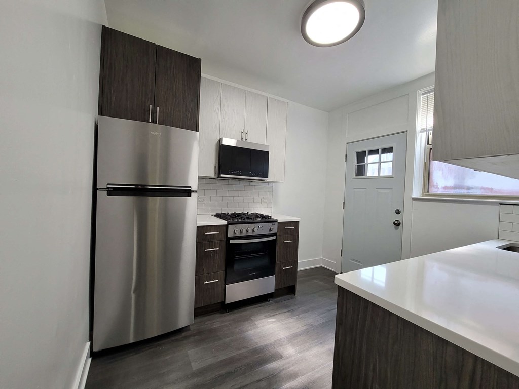an empty kitchen with a stainless steel refrigerator and stove